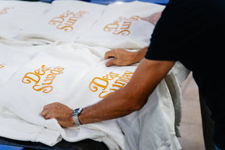 Dear Sunday hoodies printing being handled by a person.